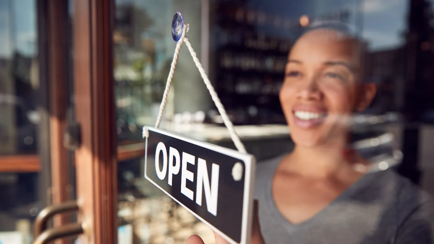 An image of a woman at open sign.