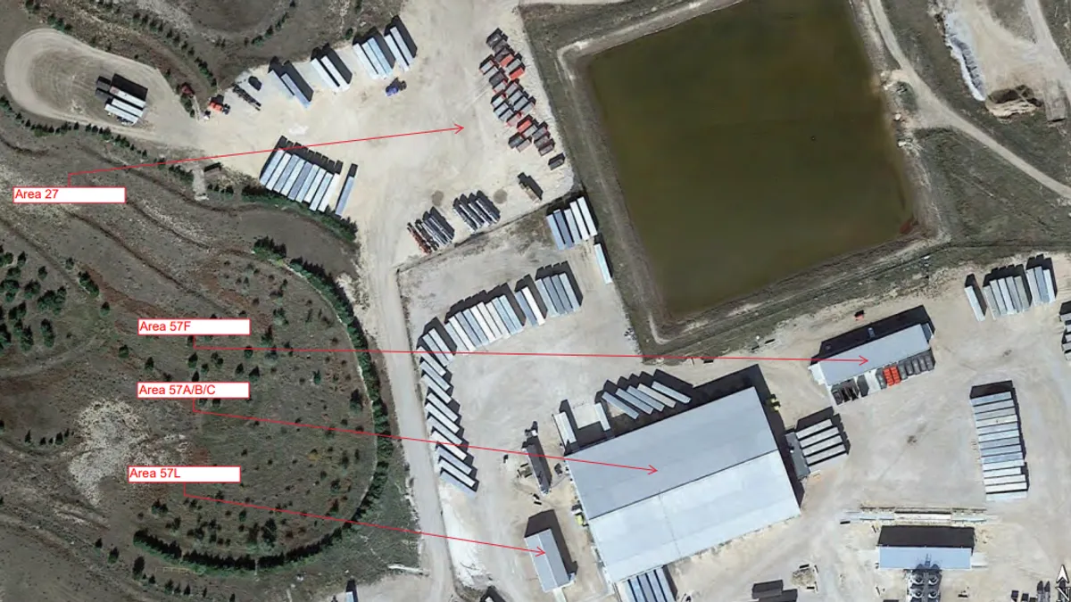 An aerial view of a facility showing outdoor truck parking areas and large warehouses or sheds.