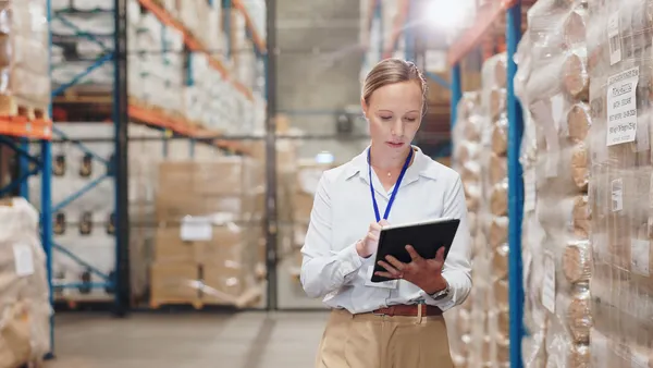 Warehouse check with tablet by business woman