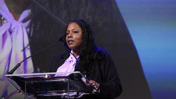 A person speaks while standing in front of a podium.