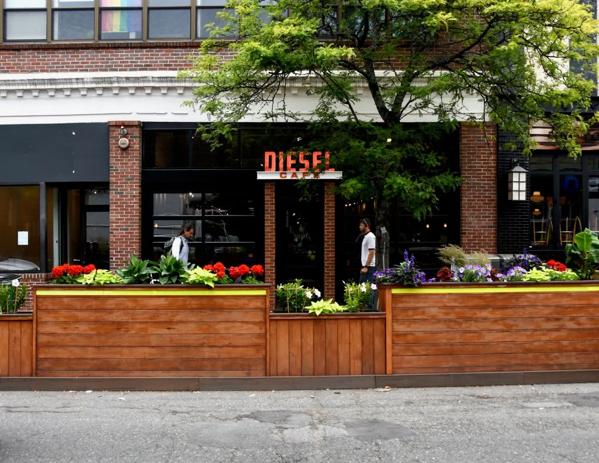 An image of a brick building with flowers in front. Signage says Diesel Cafe.