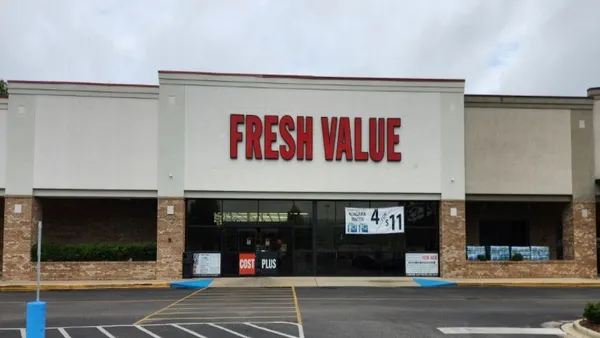 Exterior a supermarket with the words "Fresh Value" in red above the entrance.