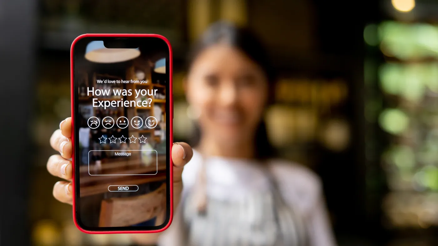 Woman displays an app to rate your experience at a store.