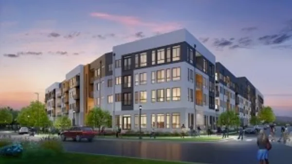 New, multi-colored, four-story apartment property, with a street in the foreground.