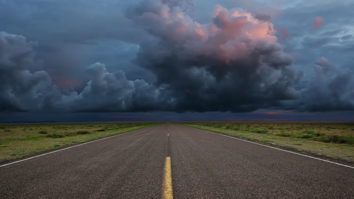 A dark cloud is seen over a road.