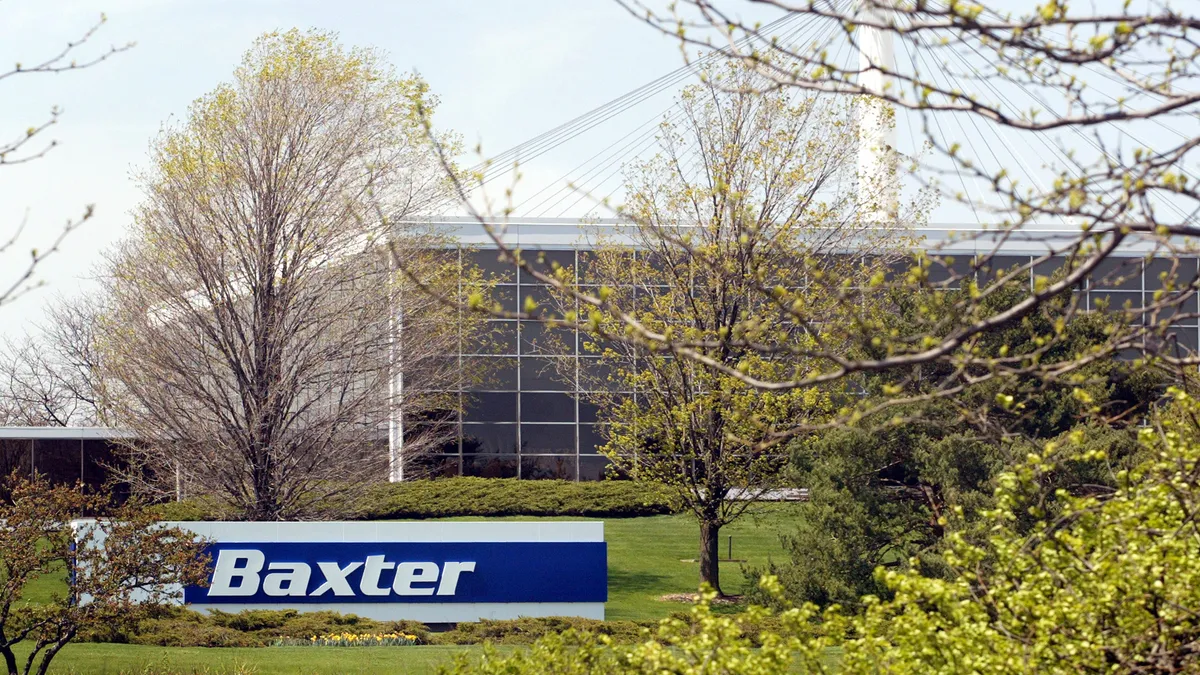 A windowed building surrounded by trees with a sign "Baxter" in front