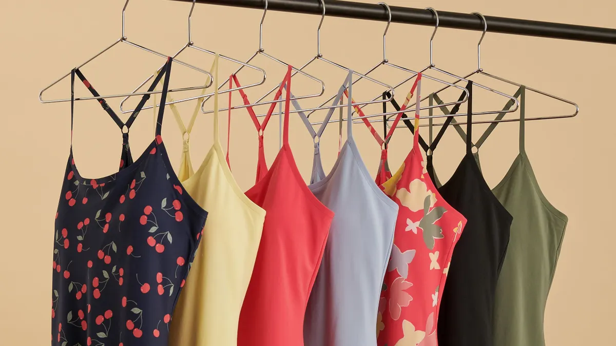 A row of colorful exercise dresses on hangers.