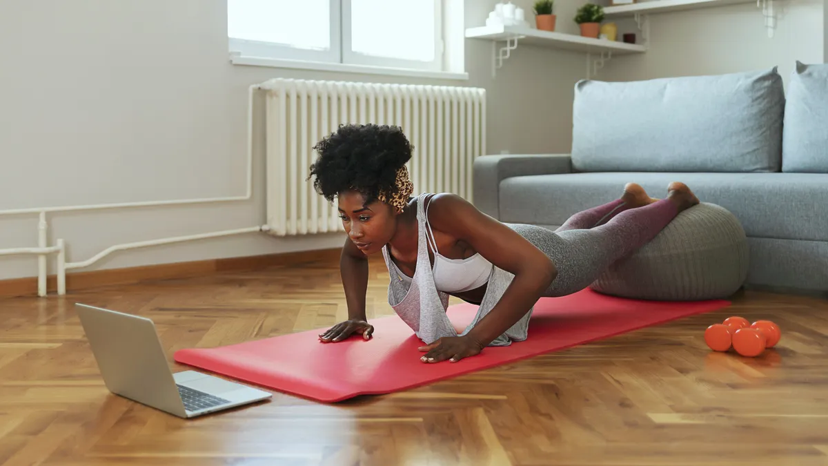 Woman exercising at home through virtual event