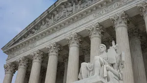 The outside of the U.S. Supreme Court with blue sky and clouds in the background.