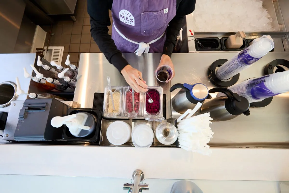 A close up of a Taco Bell worker preparing a drink.