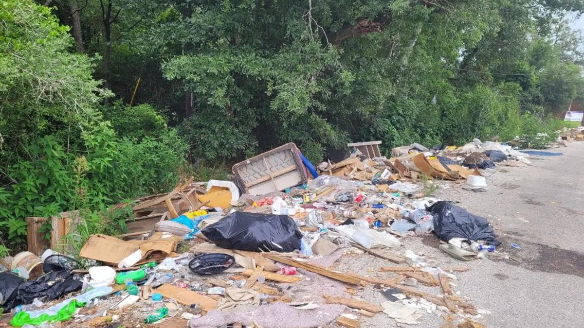 A street littered with household trash and old furniture