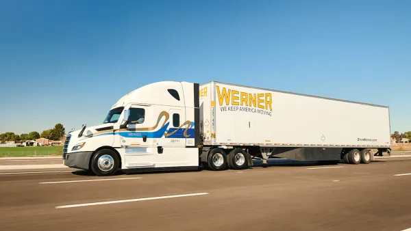 A freight truck with the Werner Enterprises logo on the road.