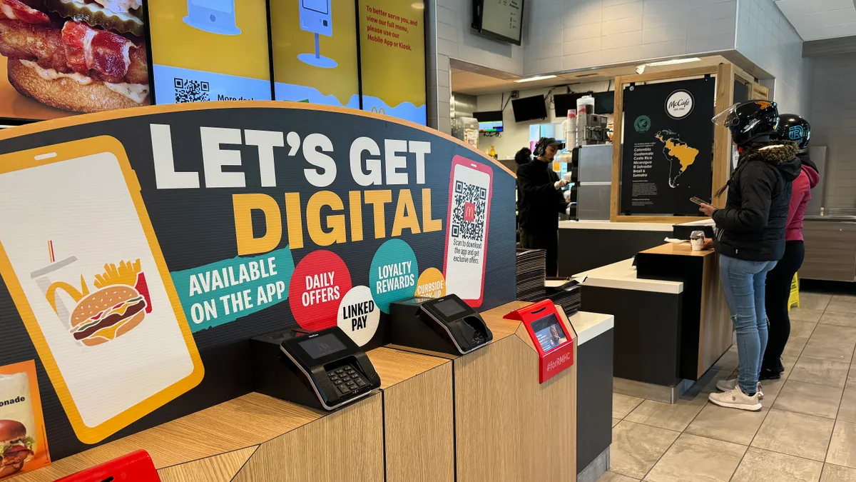 A sign advertising a digital ordering app is displayed at a McDonald's.