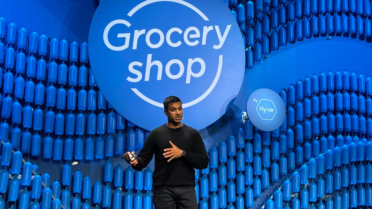 A person speaking on a stage at a conference.