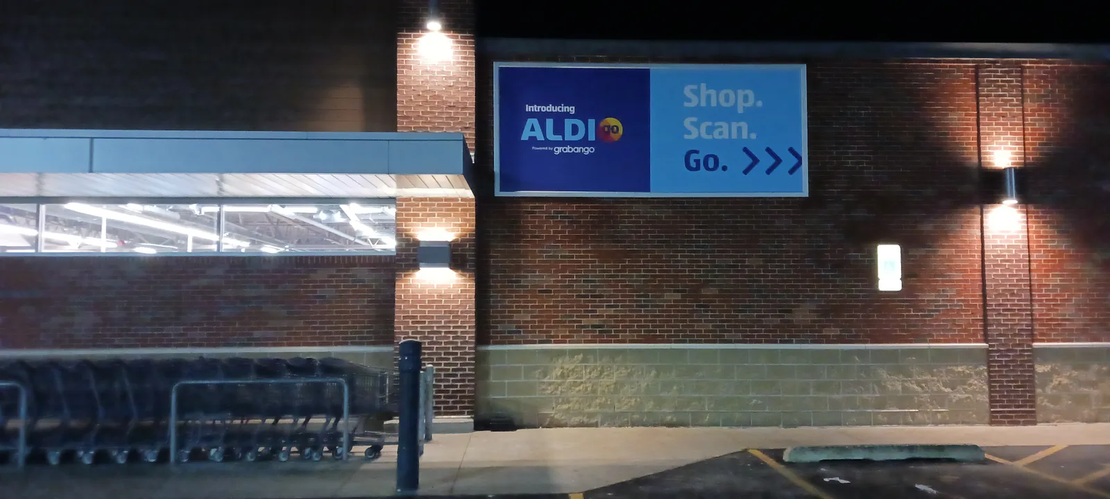 Aldi grocery store exterior at night with lights and sign.