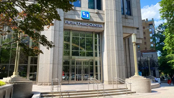 A stone building facade with the Fifth Third logo and "Fifth Third Center" above the entrance is shown, with tree branches in the foreground.