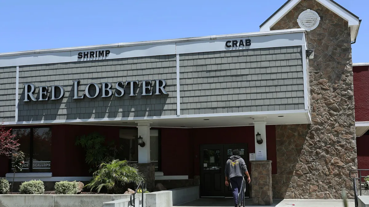 A customer walks up to a closed restaurant with a logo that says "Red Lobster"