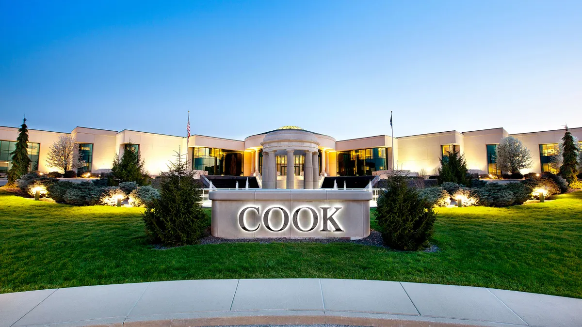 Exterior view of a building with columns and a sign that says "Cook."