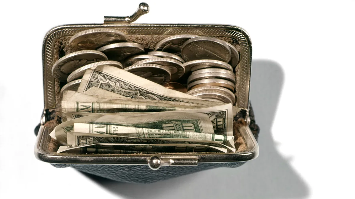 A black pocketbook with cash and coins.