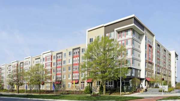 Modern brick apartment building next to street.