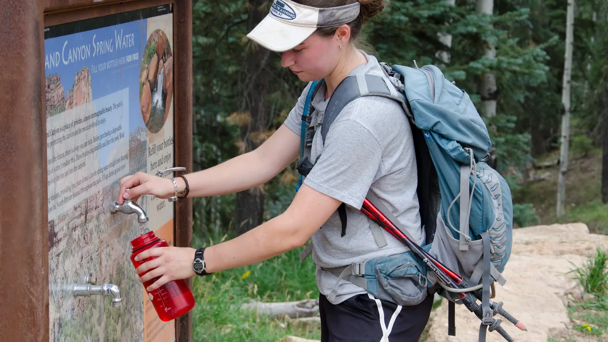 Person filling up water bottle in a national park