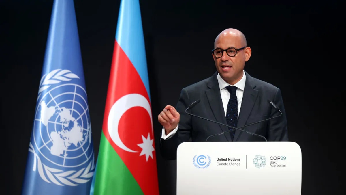 UNFCCC Executive Secretary Simon Stiell delivers a speech in front of a podium.