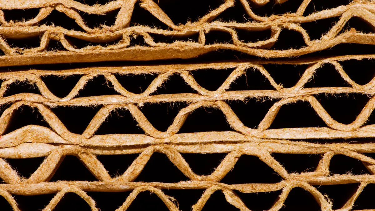 Close-up view of the edge of flattened corrugated boxes, showing the corrugating medium between the linerboard layers.