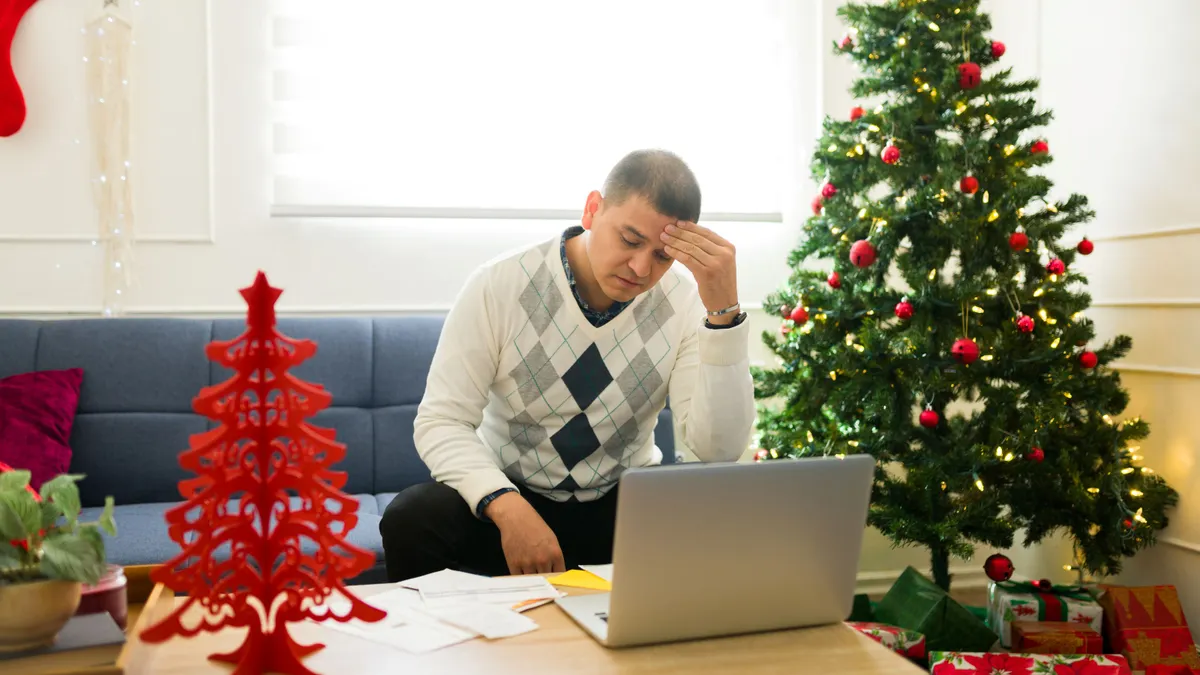 Stressed hispanic man paying for a lot of christmas gifts