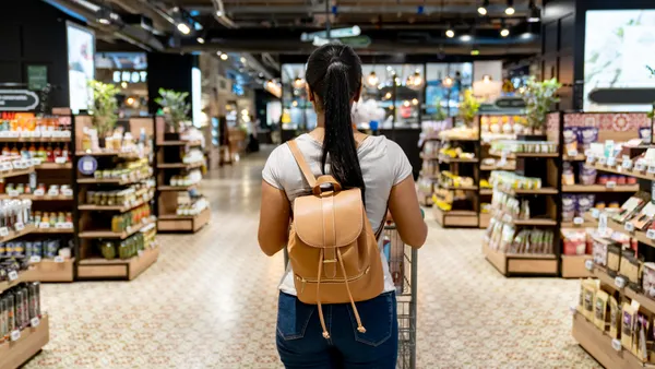 A shopper walks down a grocery aisle