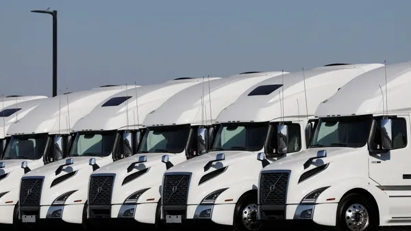 Heavy-duty trucks are displayed at a dealership