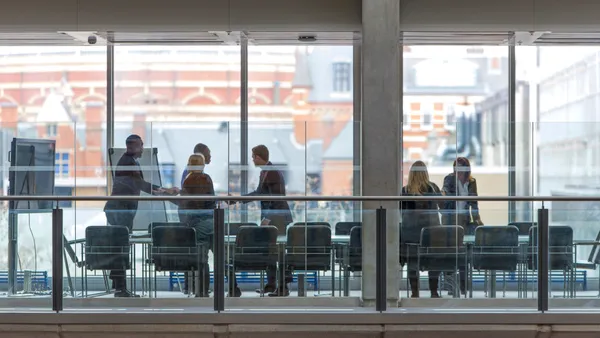 an exterior shot of a corporate boardroom as a meeting takes place