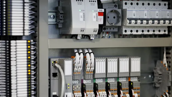 Industrial control equipment, including programmable logic controllers, are seen mounted to a wall