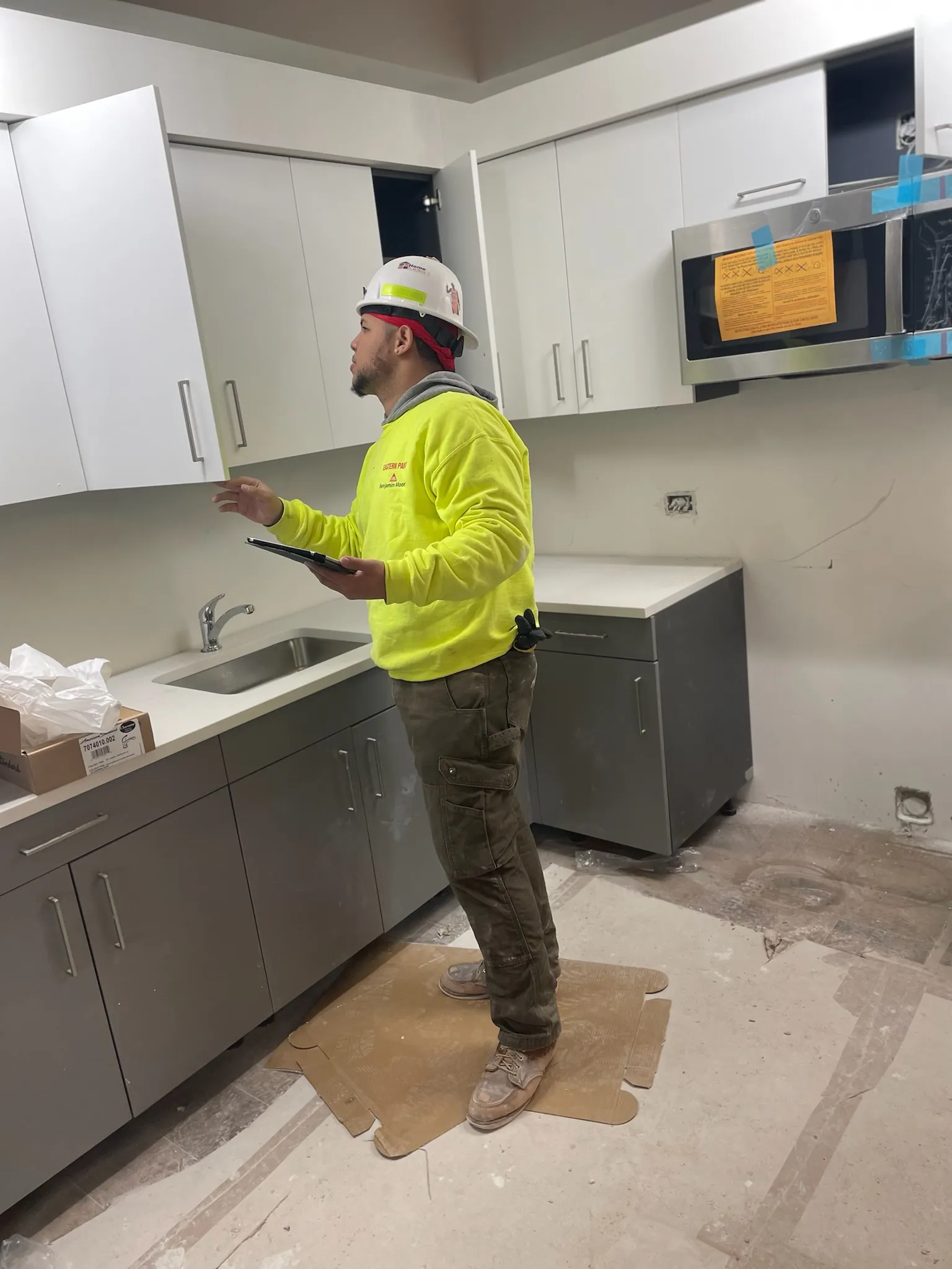 A construction worker surveys a kitchen under work.