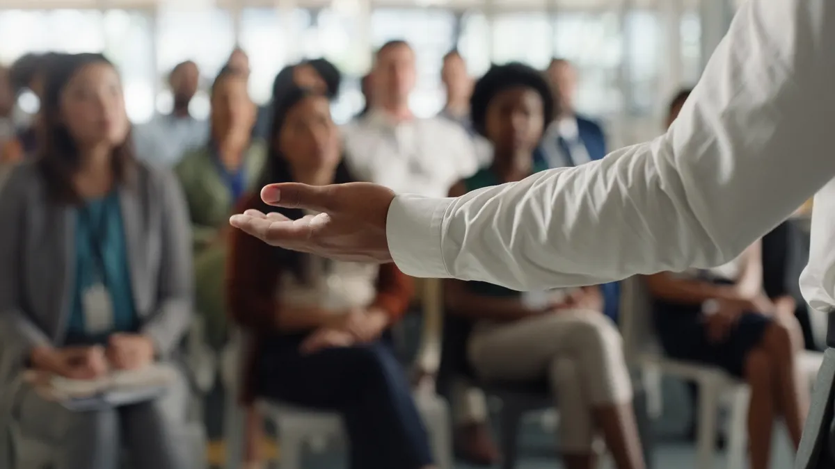 a leader's arm outstretched in front of an audience