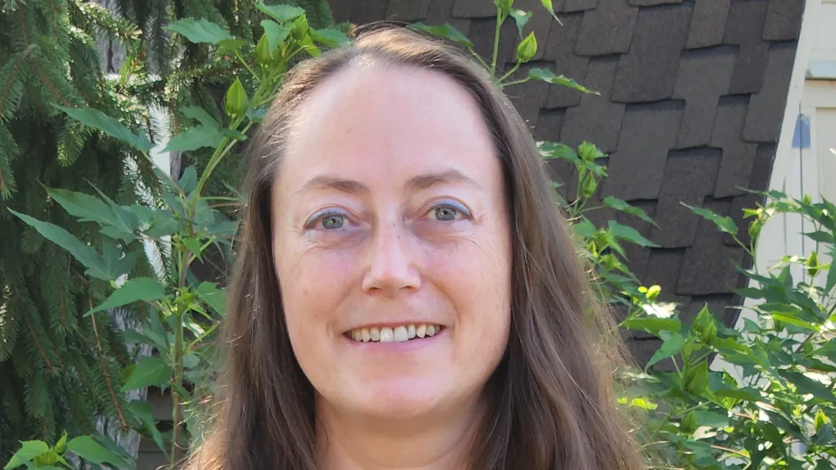 Naomi Schwartz, MedCrypt's Senior Director of Quality and Safety, stands in front of a leafy background.