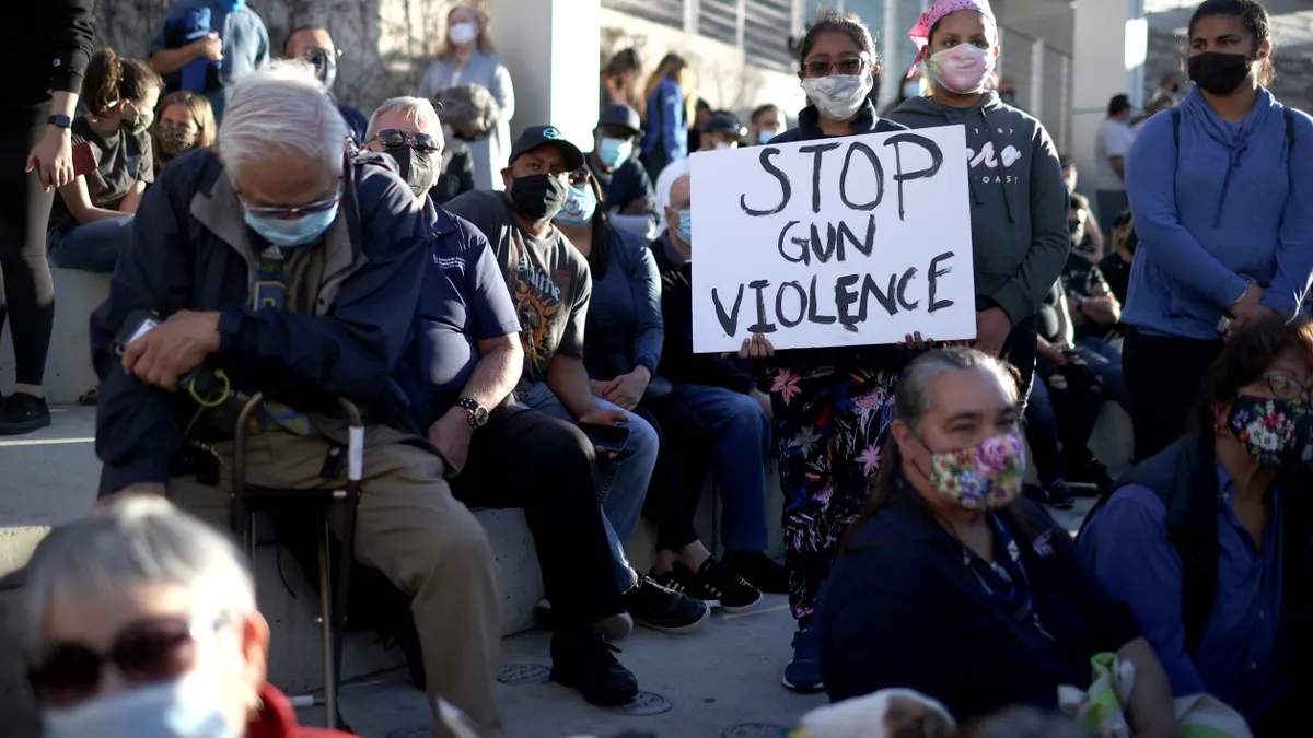 A mourner holds a sign during a vigil for the nine Santa Clara Valley Transportation Authority light rail yard shooting victims.