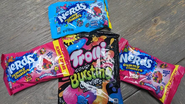 Three bags of Nerds Gummy Clusters, surrounding Trolli Sour Bursting Crawlers
