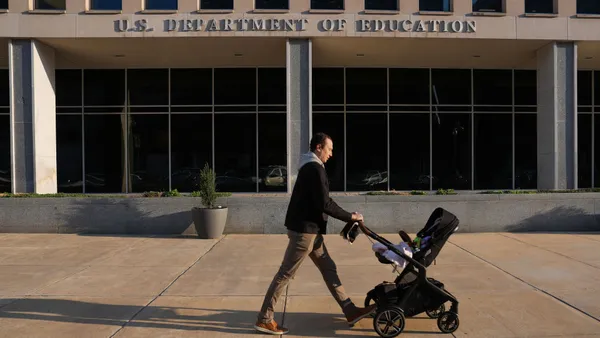 A person pushed a baby stroller past the outside of the U.S. Department of Education's building.