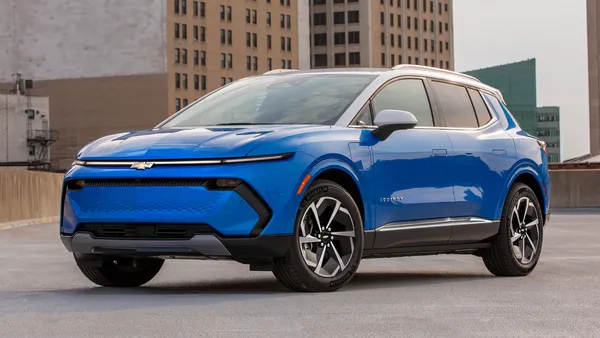 A blue Chevy Blazer EV parked on a urban rooftop with buildings in the background.