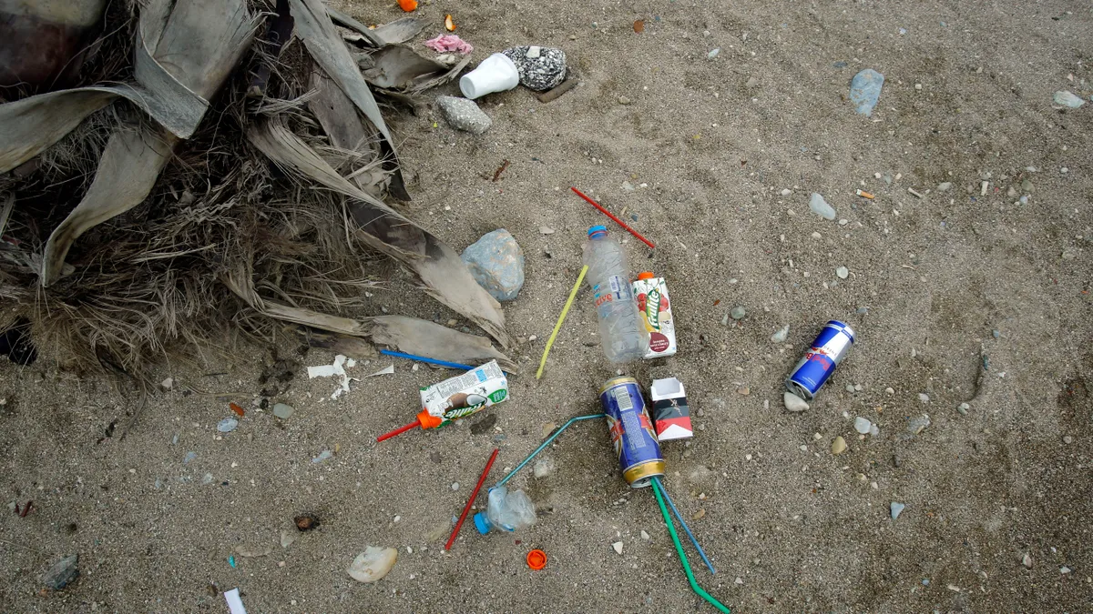 Bottles and cans littered on a sand beach