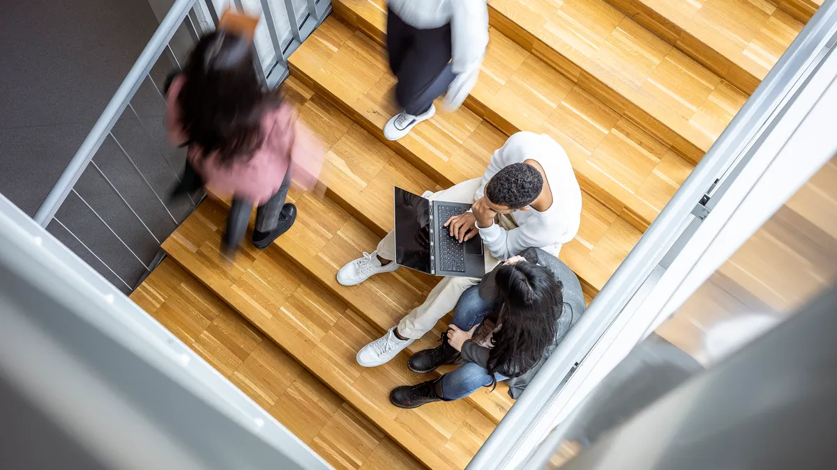 A busy staircase with several college students.