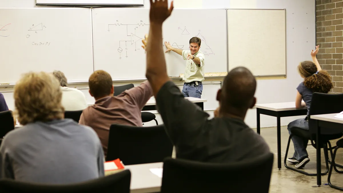 Adult education teacher in front of his class.