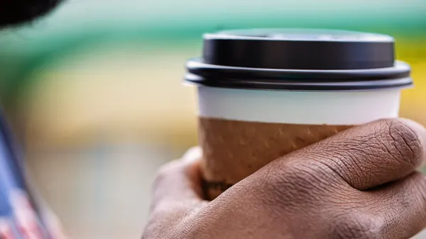 A hand holding a coffee cup