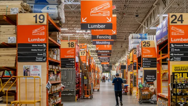 A person walks through an aisle within a Home Depot store.