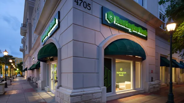 The corner of a stone building is shown, with awnings over windows and "Huntington Bank" signage and logo on each side of the building.