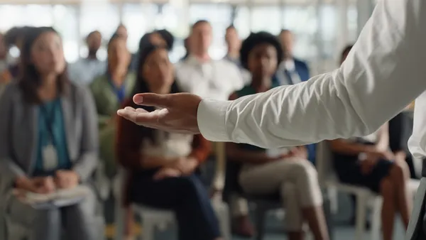 a leader's arm outstretched in front of an audience