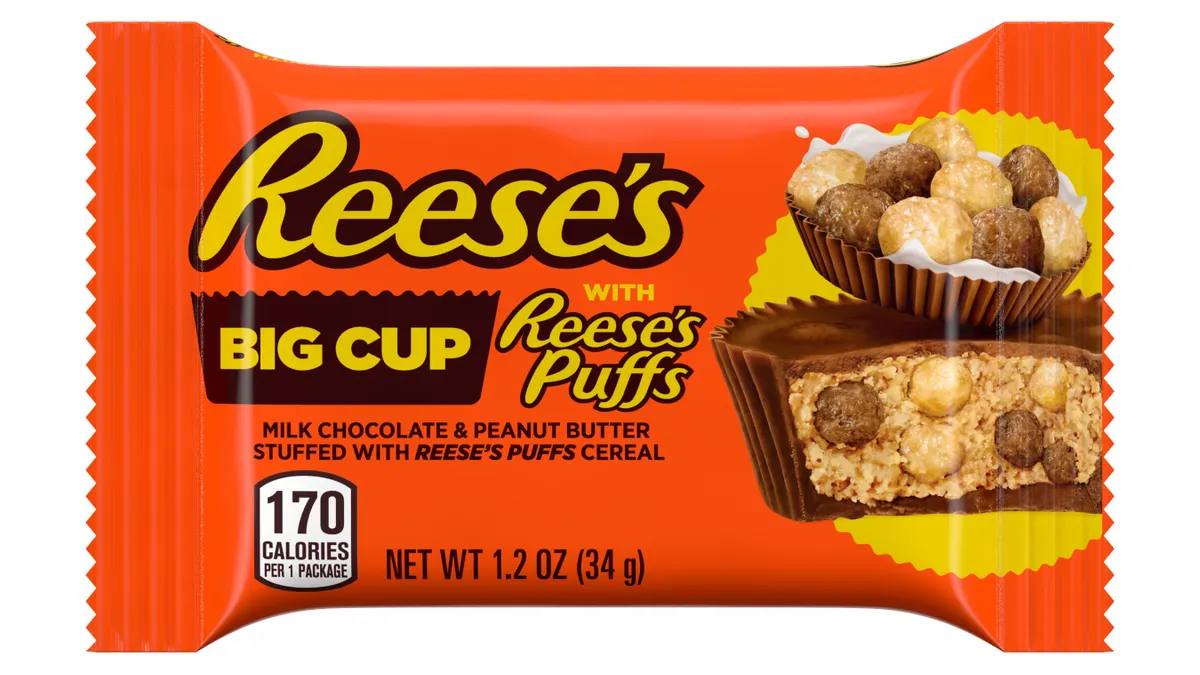 An orange package of Reese's Big Cups Stuffed with Reese's Puffs on a white background.