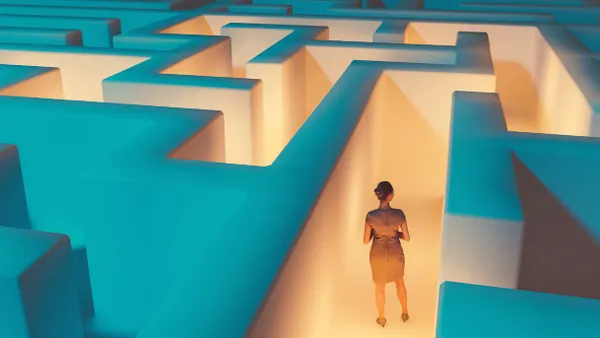 Woman stands in the middle of dark maze. Lights guide the way for her. Concept of standing in front of a challenge and finding the right solution to move on.