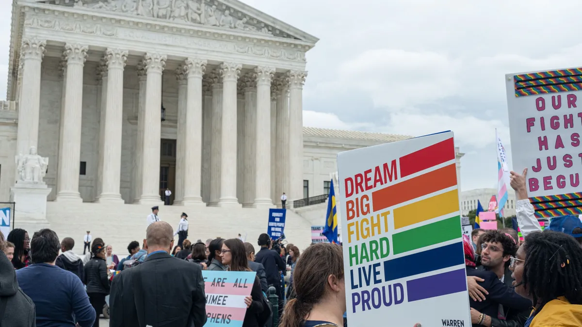 Group of people gather with signs in front of a federal building.