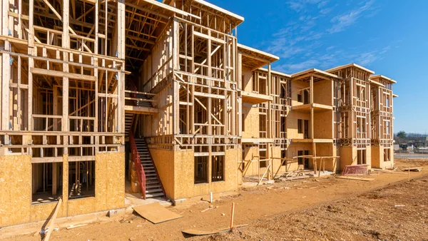 Horizontal shot of a wood-framed apartment complex under construction.